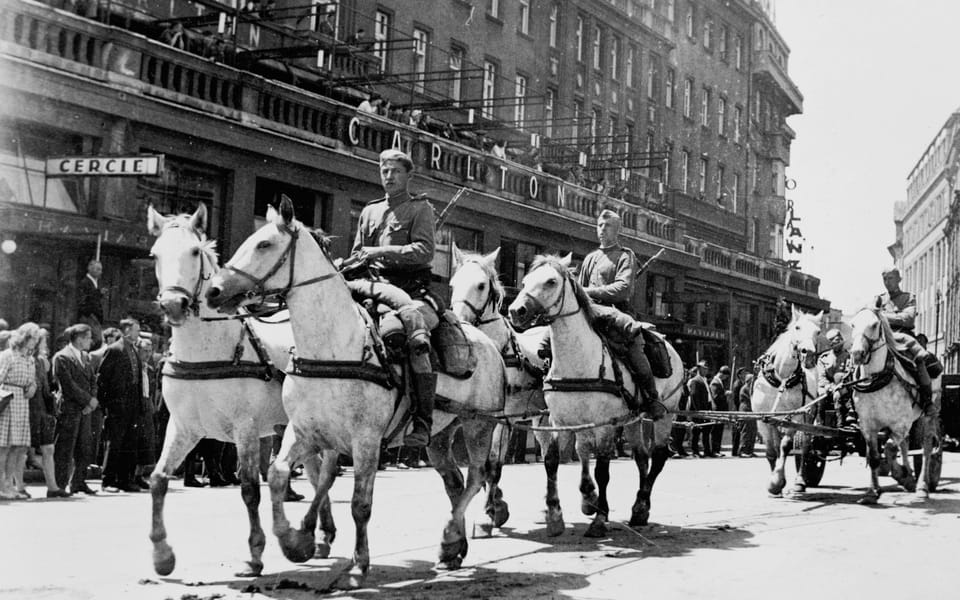 Soviet artillerymen ride on horseback past the Hotel Carlton in Bratislava: The Battle for Bratislava 1945