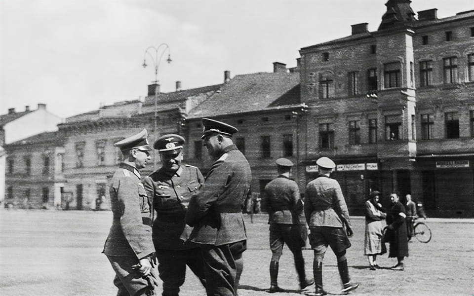 Strolling SS officers and a Jewish woman with an arm band on the market square in Auschwitz in 1940