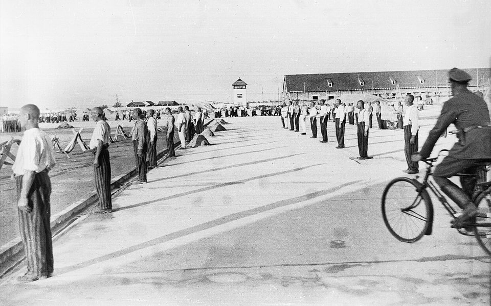 SS guard on a bicycle crossing the Dachau compound during a roll-call, early 1930s