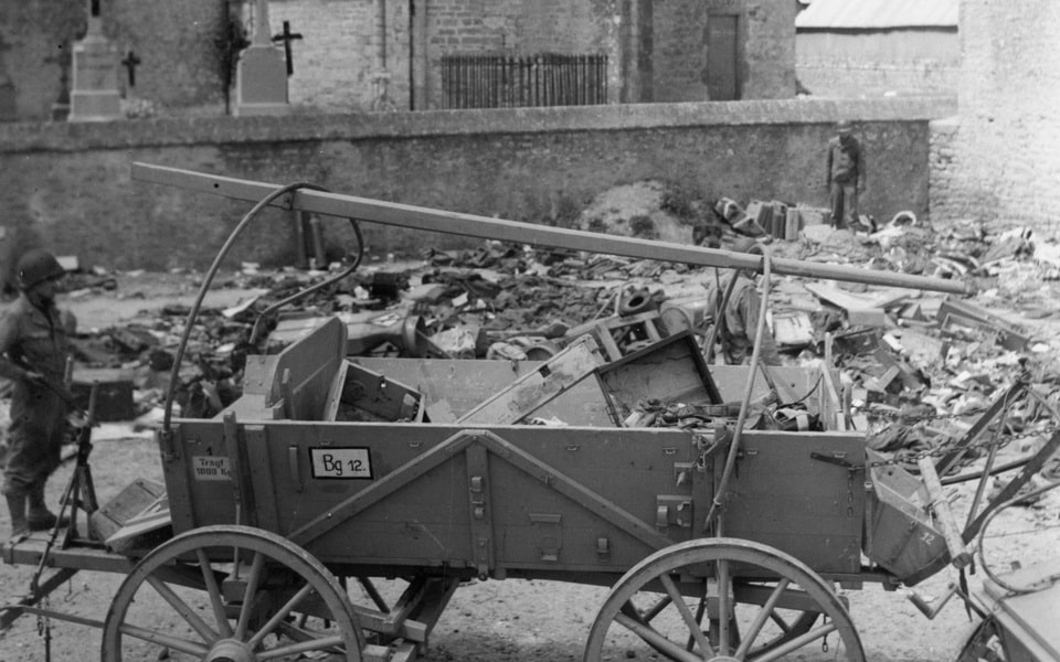 A GERMAN WAGON IS USED BY AMERICAN TROOPS IN SAINT MERE EGLISE, FRANCE ON 17 JUNE 1944
