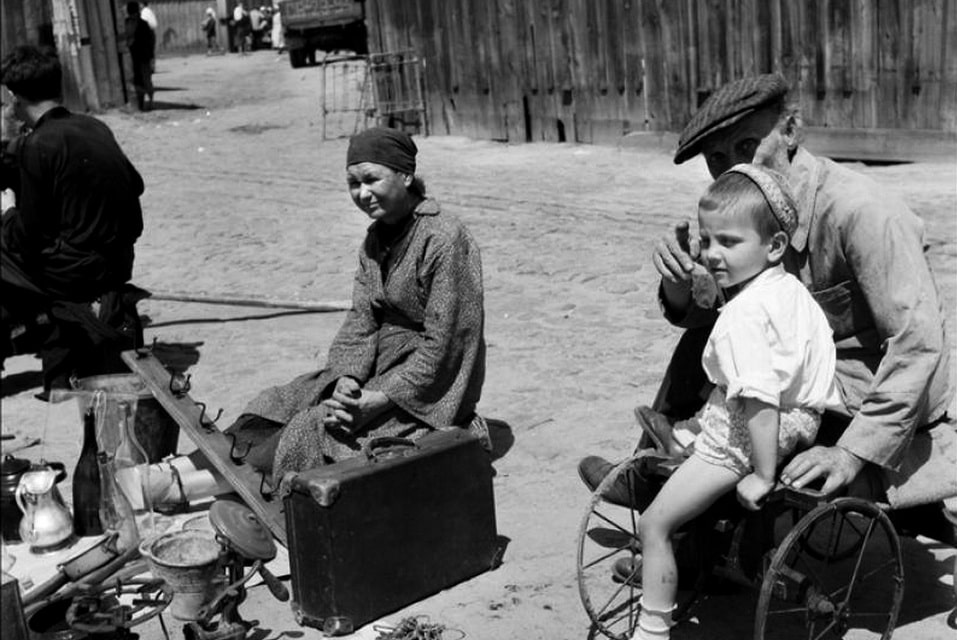 Grandfather and grandson sell old junk, sitting on a makeshift cart