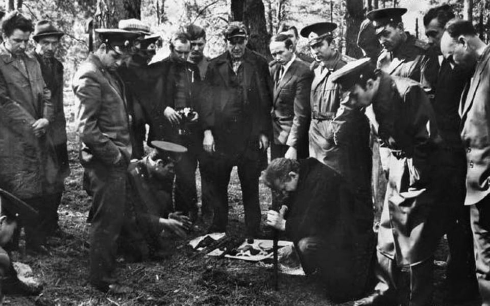 KGB officers look on as a forensic expert examines human bones extracted from the Bykivnia mass graves. April 1971