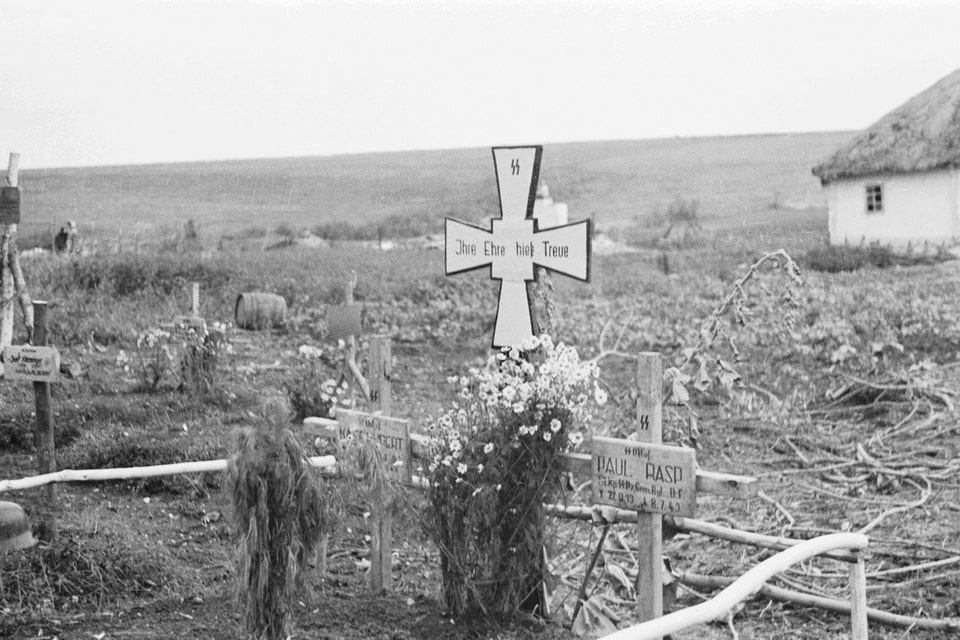 The inscription on the near cross is SS Obersturmführer Paul Rasp (09/27/1913-07/08/1943), who died on July 8, 1943