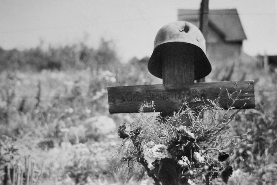 Broken Stahlhelm (steel helmet) placed on the grave of a German corporal — a common burial tradition on the Eastern Front, 1941–1945