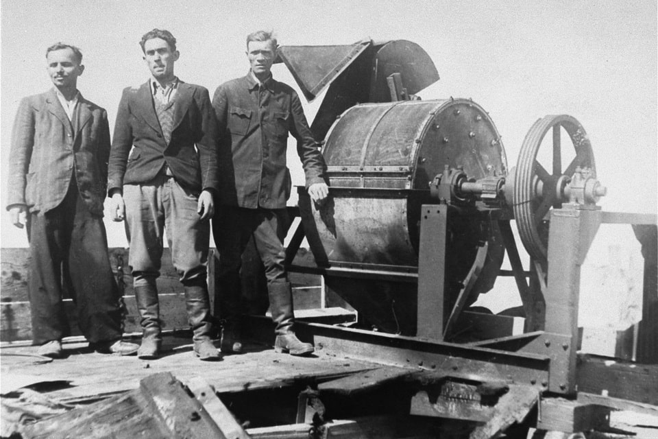 Jewish prisoners forced to work for a Sonderkommando 1005 unit pose next to a bone crushing machine in the Janowska concentration camp