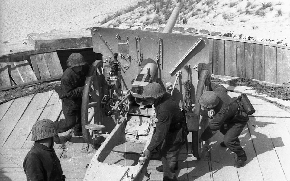 AGerman soldiers manning a gun position to cover the Normandy dunes — Atlantic Wall coastal defense 1943–1944