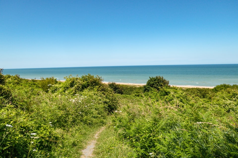 Omaha Beach dunes and beach paths today — terrain American soldiers crossed under fire on June 6, 1944