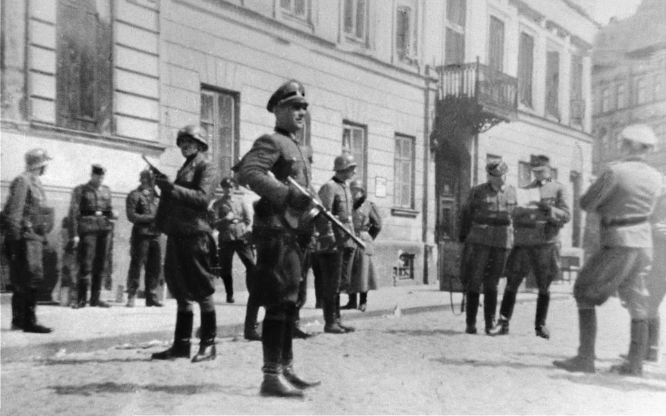 SS and police officers look on as SS Major General Juergen Stroop discusses razing the houses on Niska and Muranowska Streets with Kaleschke, his police adjutant