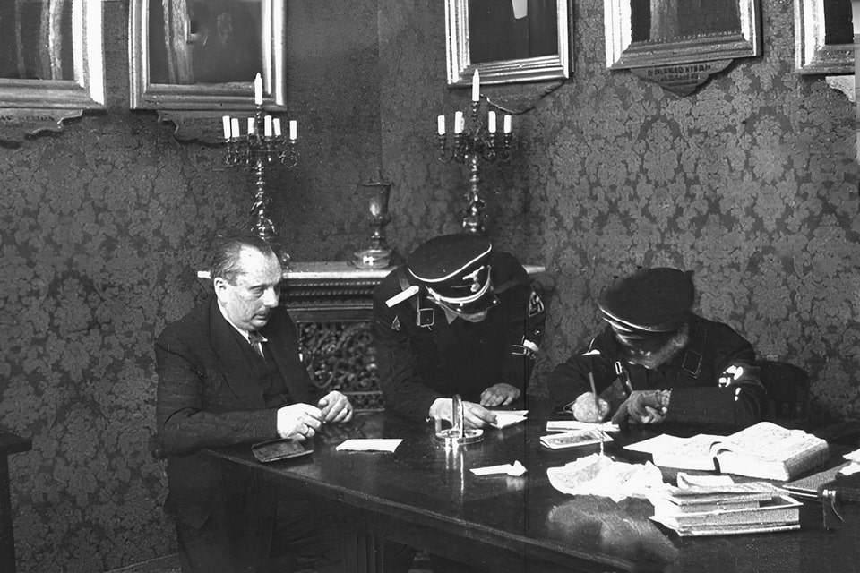 SS men Adolf Eichmann and Herbert Hagen interrogate Josef Löwenherz of the Jewish Congregation. Vienna, 18 March 1938