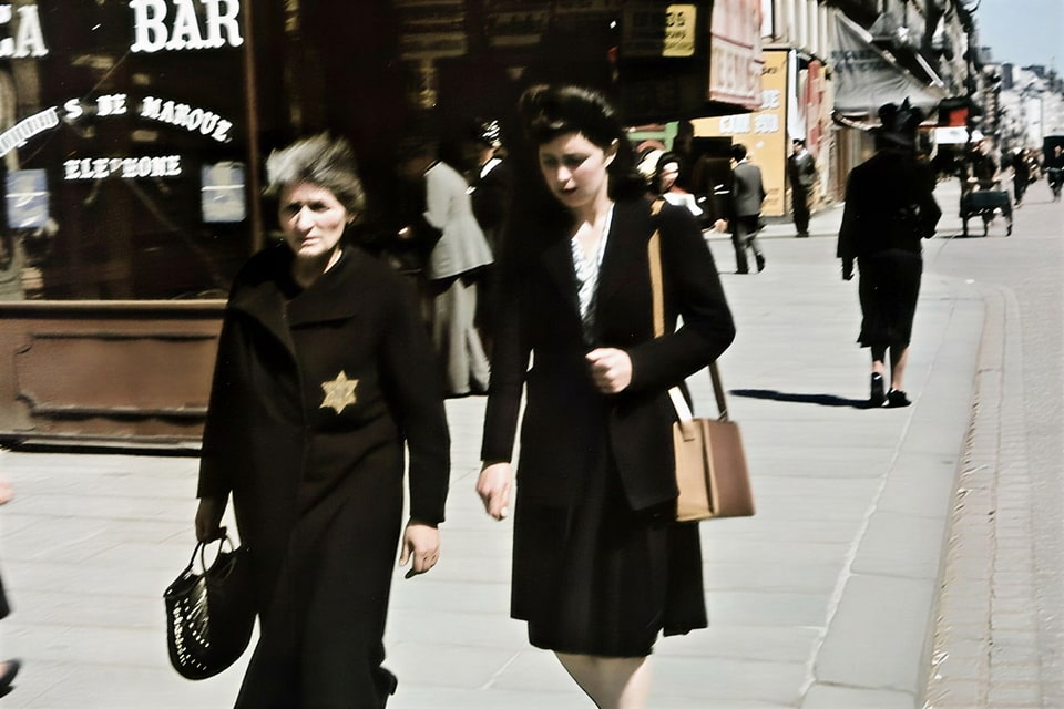 women on the street of occupied Paris with a yellow star on her clothes