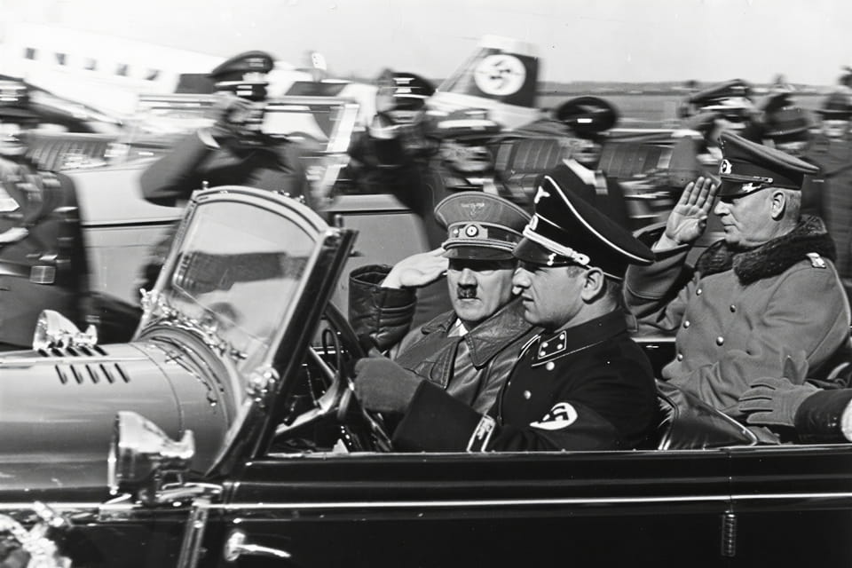 Adolf Hitler and Wilhelm Keitel arrive at Munich’s airport and drive in an open car heading east towards Austria on 12 March