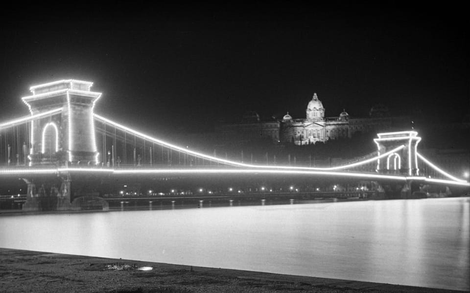 Chain Bridge and Royal Palace lit up at night, seen from the lower Pest embankment in 1938: the quay that became an Arrow Cross execution site in 1944